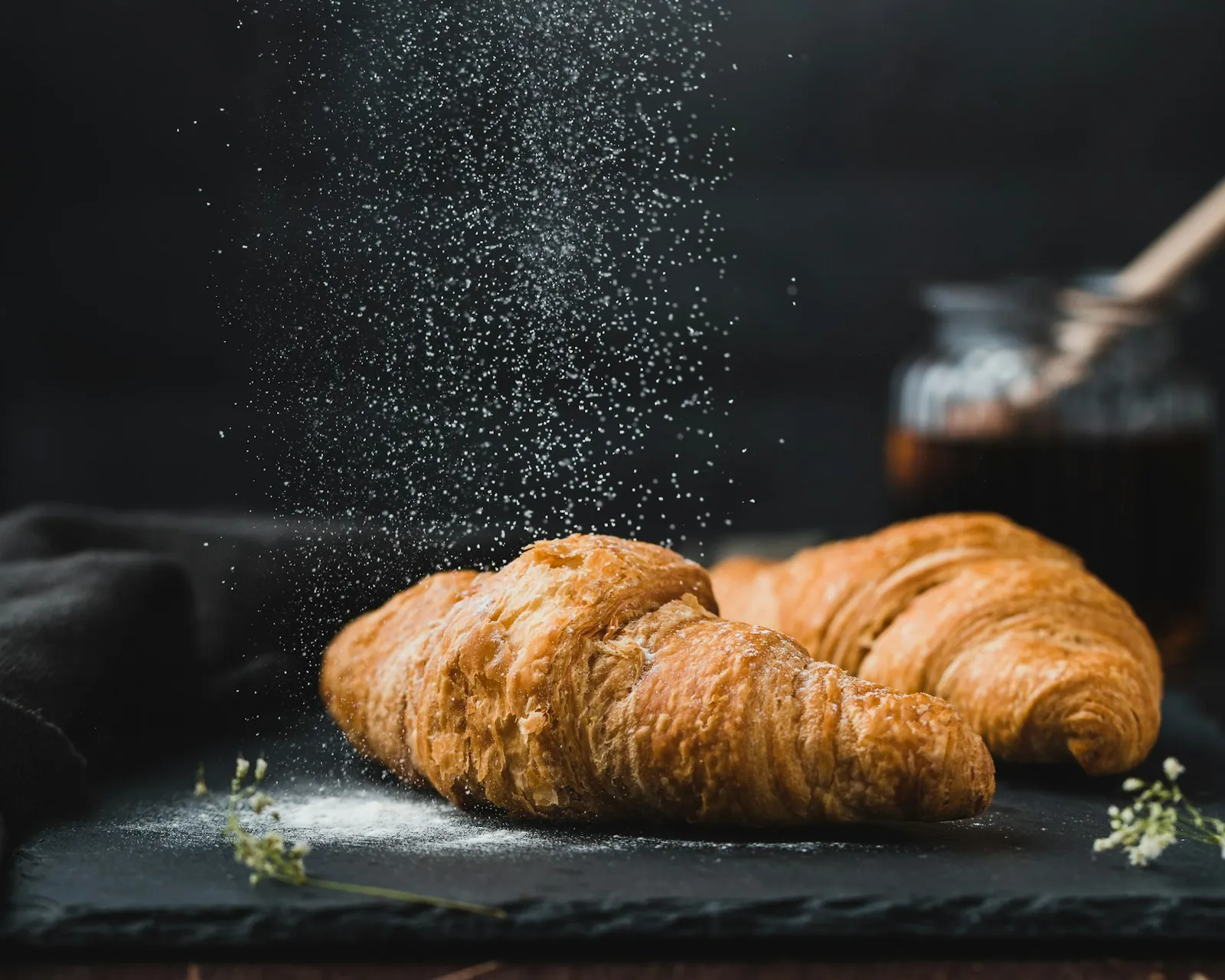 Two croissants dusted with icing sugar
